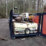 Reeds dumpster with parts of an old camper in it