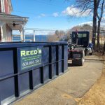Reeds Dumpsters and Demolition LLC truck dropping off a dumpster