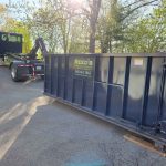 Rental dumpster from Reeds Dumpsters and Demolition LLC getting dropped off by truck