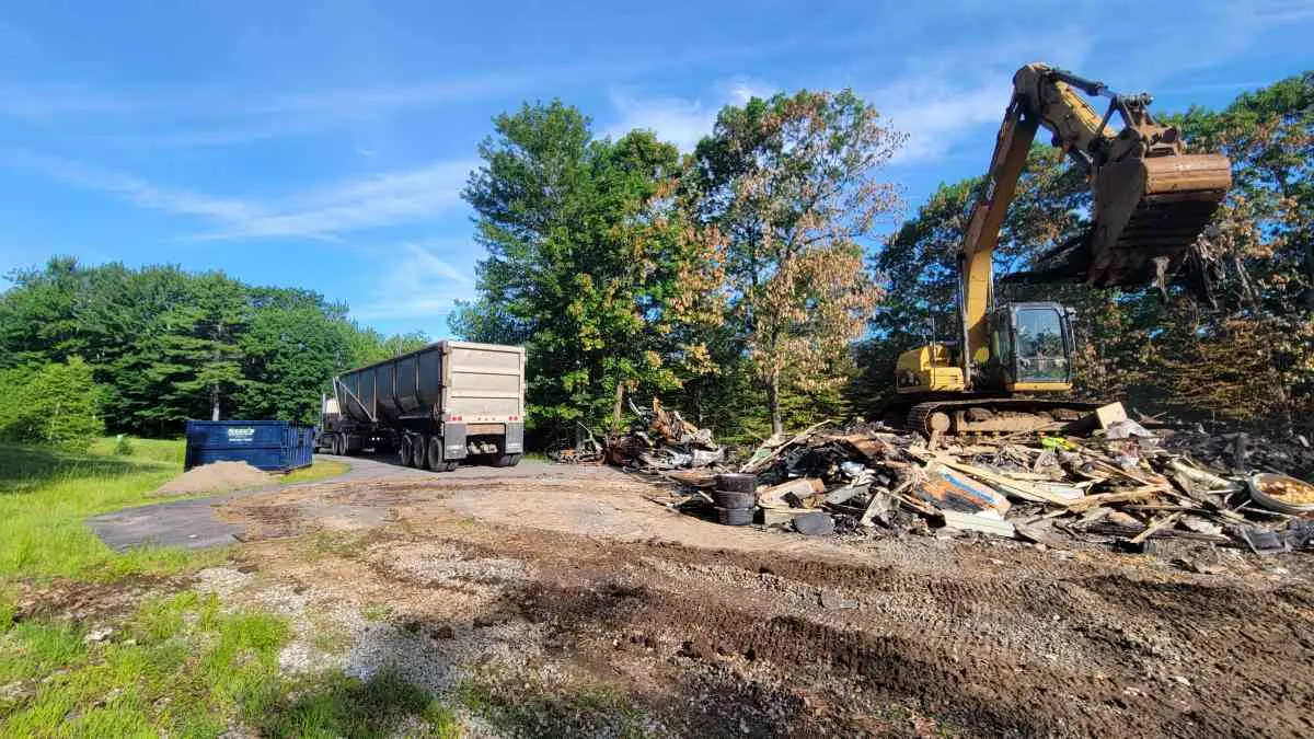 Reeds Dumpsters and Demolition LLC truck dropping off a rental dumpster